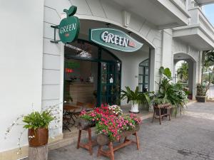 富國的住宿－Green Inn Phu Quoc Hotel，一座绿色的旅馆,在一座建筑前方,鲜花盛开