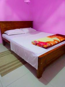 a bed in a room with a pink wall at B.Rose House in Hatton