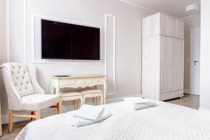 Biała sypialnia z łóżkiem, krzesłem i biurkiem w obiekcie Filip Pokoje - Osłonino nad zatoką w mieście Osłonino