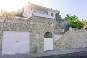 un edificio con puerta de garaje y pared de piedra en Preciosa casa en Sant Cebrià de Vallalta en Sant Cebrià de Vallalta