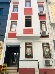 伊斯坦布尔Halil Bey Konağı的白色的建筑,有红色的门窗