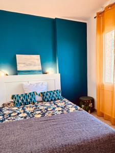 Schlafzimmer mit einem Bett mit blauer Wand in der Unterkunft Superbe T2 vue mer avec ascenseur in Canet-en-Roussillon