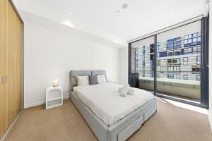 a bedroom with a large bed and a large window at Executive Two-Bedroom Apartment in Macquarie Park in Sydney
