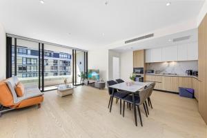a kitchen and living room with a table and chairs at Executive Two-Bedroom Apartment in Macquarie Park in Sydney