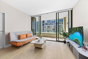 a living room with a couch and a large window at Executive Two-Bedroom Apartment in Macquarie Park in Sydney