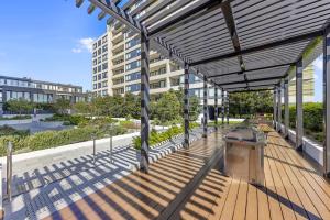 an outdoor patio with a grill on a building at Executive Two-Bedroom Apartment in Macquarie Park in Sydney