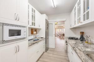 a kitchen with white cabinets and a sink at Casa Cañi in Málaga
