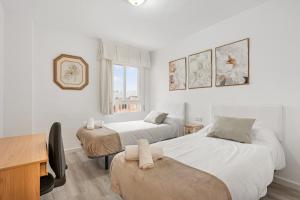 a bedroom with two beds and a desk and a desk at Casa Cañi in Málaga