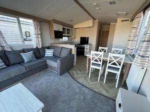 a living room with a couch and a table at Dainville Caravan Park in Skegness
