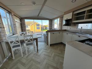 a kitchen with a table and chairs and a dining room at Dainville Caravan Park in Skegness
