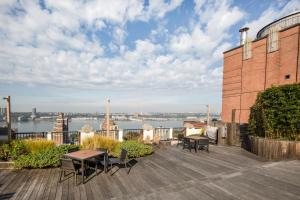 eine Terrasse mit Tischen und Stühlen auf einem Gebäude in der Unterkunft Upper West Side 1br w doorman nr park NYC-1219 in New York