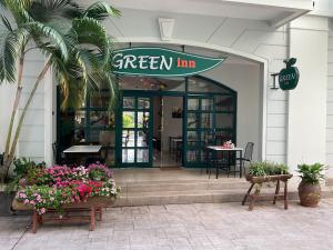a green inn restaurant with flowers in front of it at Green Inn Phu Quoc Hotel in Phu Quoc