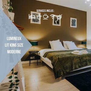 a bedroom with a king sized bed and posters on the wall at Le Bertrand • Le Raffinement en Cœur de Ville in Châteauroux