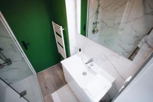 a bathroom with a white sink and a mirror at Le Bertrand • Le Raffinement en Cœur de Ville in Châteauroux +29 photos