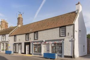 an old white building on the side of a street at Number 55 Apartment in North Berwick