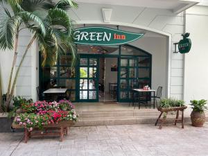 a green inn restaurant with flowers in front of it at Green Inn Phu Quoc Hotel in Phú Quốc