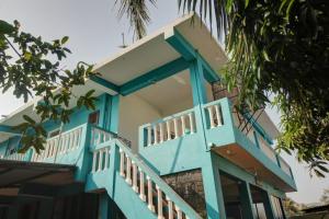 a blue and white house with a balcony at Comfort Holiday Home in Baga
