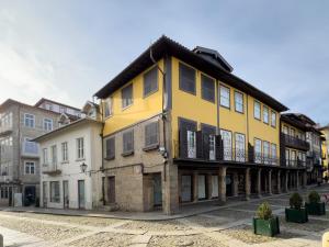żółty budynek po stronie ulicy w obiekcie Aparthotel Largo da Oliveira w mieście Guimarães
