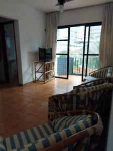 een woonkamer met 2 banken en een televisie bij Apartamento Praia Grande Frente Mar in Praia Grande