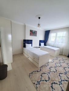 a large room with two beds and a rug at kayan apart in Trabzon