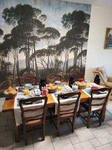 - une salle à manger avec une table et de la nourriture dans l'établissement Chambres d'Hôtes "Les Hauts Vents", à Saint-Pol-de-Léon