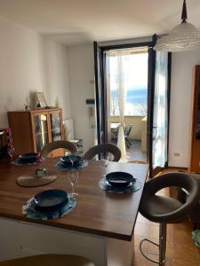 een eettafel met stoelen en een tafel met uitzicht bij Bnbook - La casa sul Lago Maggiore in Ispra