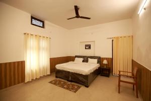 a bedroom with a bed and a ceiling fan at Awadh Punch Garden Cafe in Lucknow