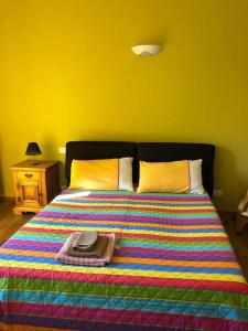 a bed with a colorful blanket and a hat on it at Ca' Cuore in Monferrato in Serralunga di Crea