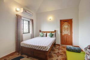 a bedroom with a bed and a green couch at Comfort Holiday Home in Baga