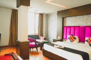 um quarto de hotel com duas camas e uma parede rosa em Hotel Sukoon - Ramesh Nagar em Nova Deli
