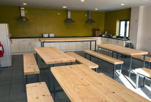 a room with wooden tables and a kitchen at Aran Islands Camping & Glamping in Kilronan