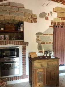 cocina con chimenea de piedra y fogones en Ca' Cuore in Monferrato, en Serralunga di Crea