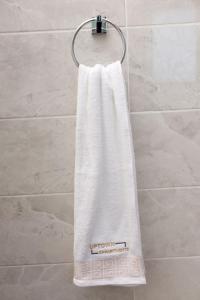 a white towel hanging on a towel rack in a bathroom at Uptown Luxury Villas in Nelspruit
