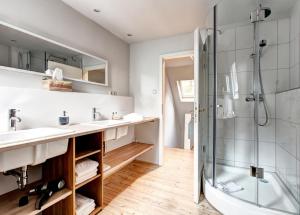 a bathroom with two sinks and a shower at Gut Thansen Forsthaus in Soderstorf