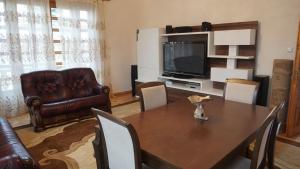 sala de estar con mesa, sofá y TV en Fortuna 2024 en Kutaisi