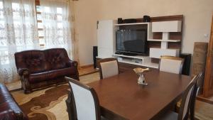 a living room with a table and a couch and a television at Fortuna 2024 in Kutaisi