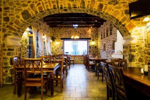 a dining room with stone walls and tables and chairs at Eos - Authentic Experience in Skíti