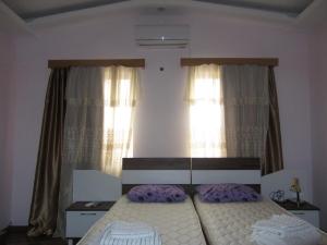 庫塔伊西的住宿－Fortuna 2024，一间卧室设有一张床和两个窗户。