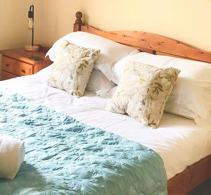 a large bed with white sheets and pillows at Chapel Cottage Winton in Kirkby Stephen