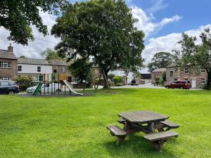 a picnic table in a park with a playground at Chapel Cottage Winton in Kirkby Stephen