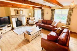 a living room with a couch and a tv at Chapel Cottage Winton in Kirkby Stephen