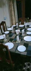 une longue table avec des plaques blanches sur une table en damier dans l'établissement Garden of Eden resort, à Srinagar