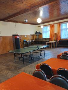 a ping pong table in a room with chairs at Prázova Bouda in Dobré