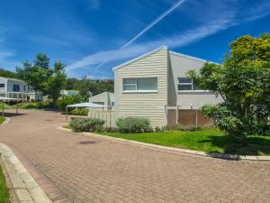 een huis aan een stenen weg naast een oprit bij 22 Oaklands on the Knoll in Knysna