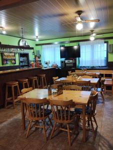 a restaurant with wooden tables and chairs and a bar at Prázova Bouda in Dobré
