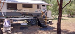 冈尼达RV Caravan in Rural Setting on Edge of Town close to AgQuip的一辆露营车停在卡车后面