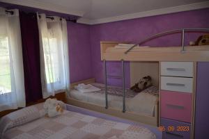 Dormitorio infantil con litera y paredes púrpuras en Cómoda casa en Cabárceno, en Villanueva