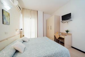 ロアーノにあるHotel Atlanticのベッドと机のある小さな寝室