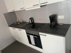 a small kitchen with a sink and a stove at Élégant appartement (quartier européen) in Brussels