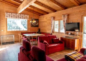 uma sala de estar com cadeiras vermelhas e uma mesa em Abrahamhütte em Kaiser